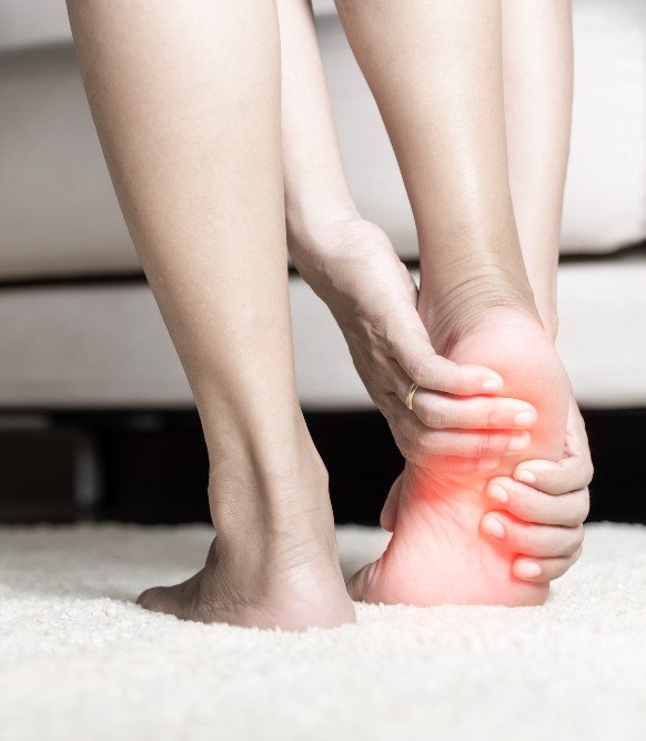 Woman grabbing feet due to heel pain
