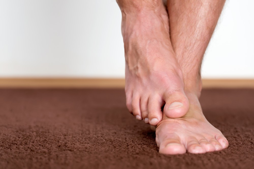 Man rubbing feet would who benefit from SMART Neuropathy Program